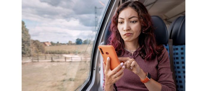 annoyed-girl-unsuccessfully-tries-to-catch-a-cellular-signal-or-an-unstable-wifi-holding-her-smartphone-in-her-hands-in-train-promotiona