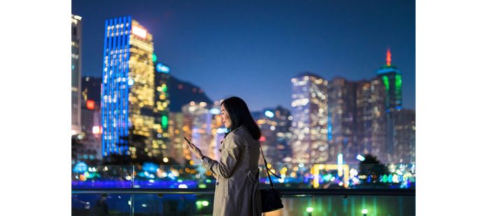 Woman-looking-at-phone-in-city-GettyImages-1126206564